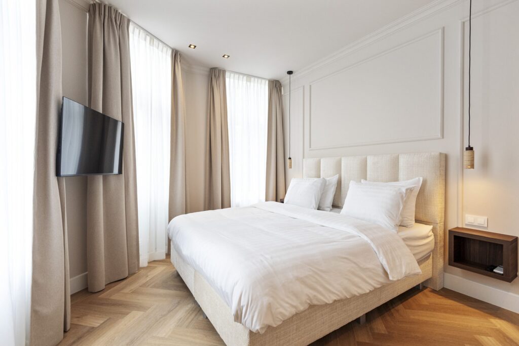 Lichte hotelkamer met kingsize bed en visgraatvloer